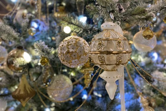 A close up of adorned blue and white decorations on a tree.