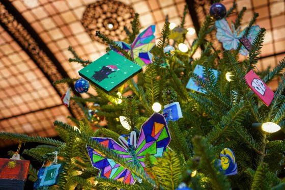 The top of a decorated Christmas tree featuring vibrant handmade ornaments.