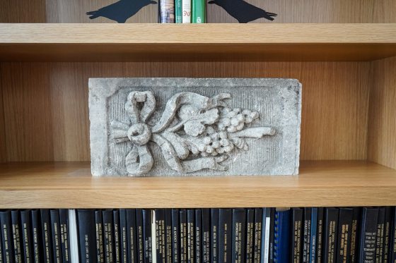 An old block of stone with a floral motif crafted on the front.