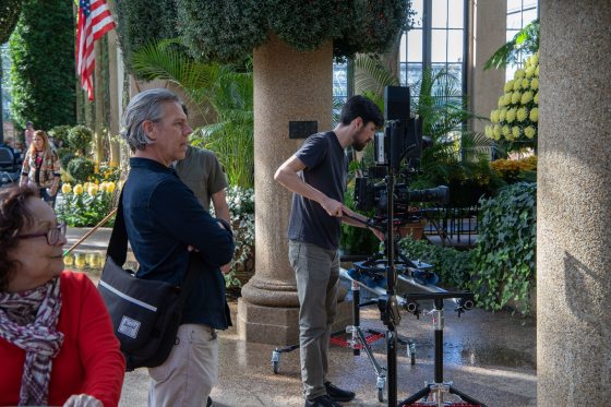 Several people filming in the Main Conservatory at Longwood Gardens.