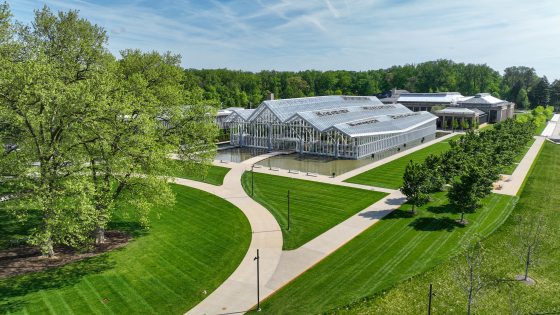 An aerial image of the Longwood Reimanged project, featuring a glass conservatory, a large grove of trees, and pathways. 