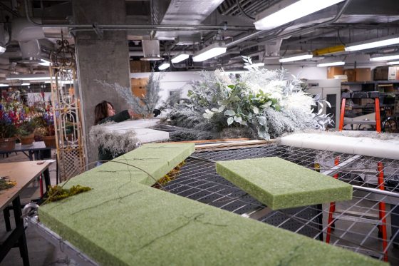 A workspace for crafting large scale floral designs, with green foam blocks laying on metal tables.