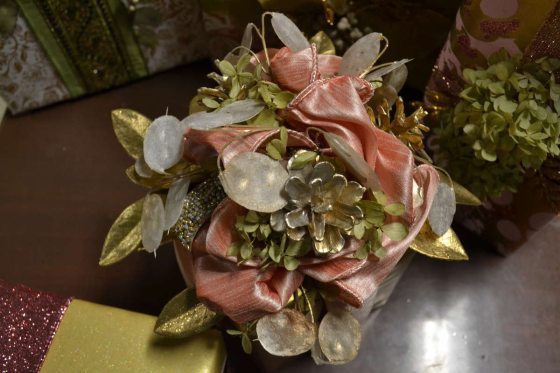 close up of a gift packaging with ribbons, plant foliages, and spray painted elements