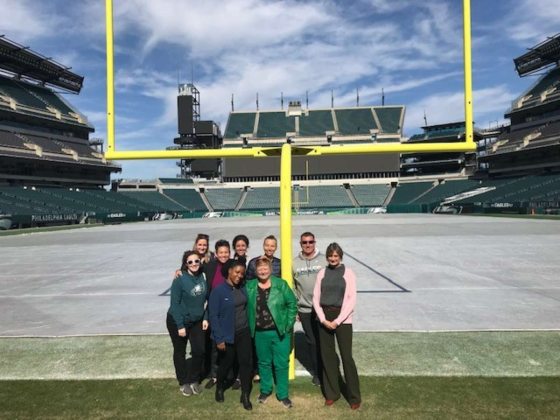 group of people standing in front of a goal post on a football field