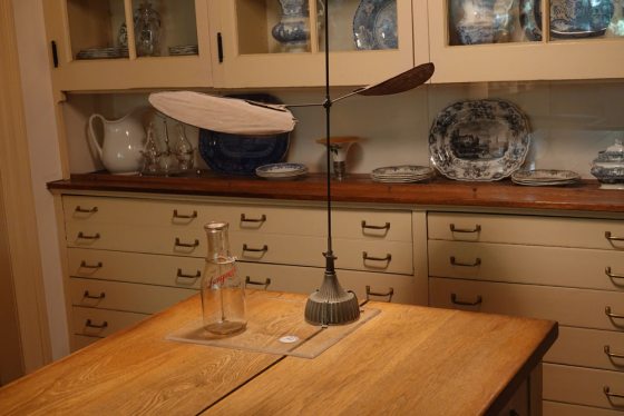 a milk bottle and cap sit atop a kitchen table 