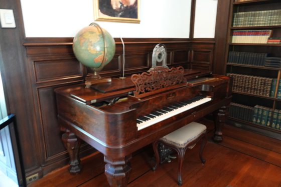 a large piano with a world globe placed on top