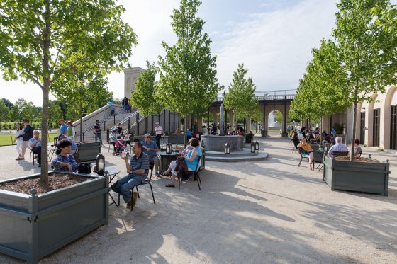 numerous people enjoying a beautiful day sitting at the Pumphouse Plaza at Longwood Gardens