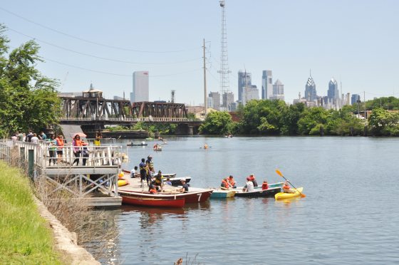 kayaks in a river with a city skyline in the background 