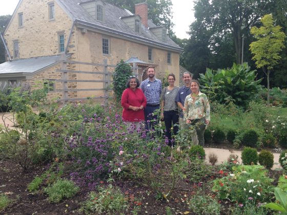 a group of five people standing in a small garden