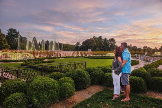 two people admiring fountains in an outdoor garden 